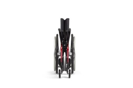 Folded wheelchair with black fabric and red accents, positioned upright on a white background.