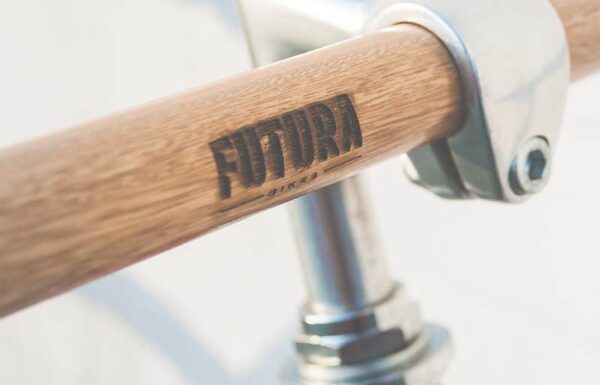 Close-up of a bicycle handlebar featuring a wooden grip and Futura branding.