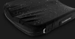 Black waterproof laptop sleeve with water droplets on the surface, showcasing its protective design.