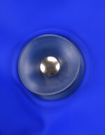 A clear suction cup with a metallic centre on a blue silicone surface.