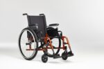 Manual wheelchair featuring a black seat and an orange frame, positioned on a neutral background.