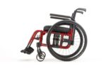 A red lightweight wheelchair with black seat and backrest, featuring large rear wheels and smaller front wheels.