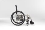 Foldable wheelchair with a black seat and large rear wheels, viewed from the side.