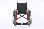 A black wheelchair with red accents, viewed from the front with a plain background.