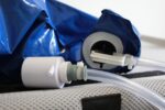 Close-up of a blue inflatable device featuring a hose connector and valve mechanism.
