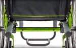 Close-up of a Spinergy release cable mechanism on a wheelchair frame in green and grey.