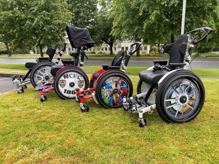 A collection of three custom wheelchairs showcasing unique designs and colors, featuring different wheel styles and seating arrangements.