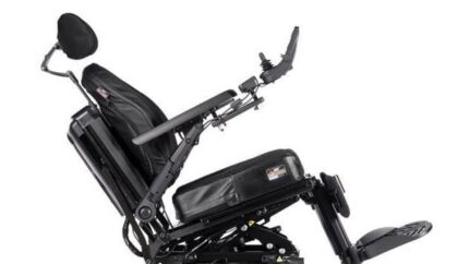 Image: A tilted back electric wheelchair shown from the side with headrest and specialist Jay Syncra seating shown