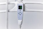 Digital handset with buttons and battery indicator for medical equipment control.