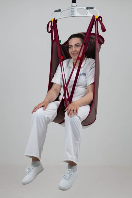 A woman seated in a high back patient sling designed for lifting and transferring individuals.