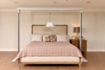 Savaria gantry bed system with a beige quilt and headboard in a bedroom setting.