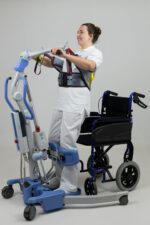 A person using a soft chest stand aid while standing next to a wheelchair.
