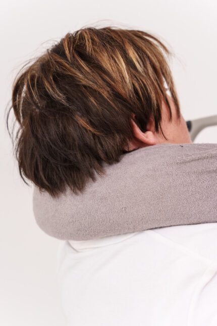 Person using a standard neck support roll around their neck for comfort and support.