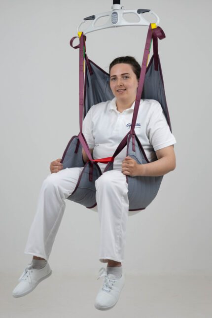 A person seated in a universal deluxe sling designed for patient lifting and support.